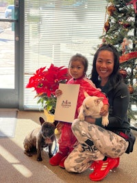 a woman and a child posing for a photo with their pets